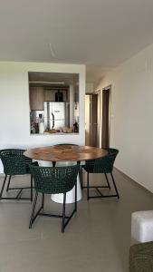 une salle à manger avec une table et des chaises et une cuisine dans l'établissement Lanai Imbassai, à Mata de São João