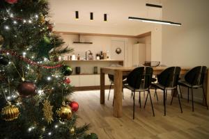 Ecolodge 4étoiles Luxe, détente et balnéo dans la forêt في Métairies-Saint-Quirin: شجرة عيد الميلاد في غرفة معيشة مع طاولة وكراسي