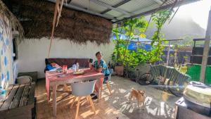 a man sitting at a table in a room with a dog at Chez Hina no Pacifica in Bora Bora