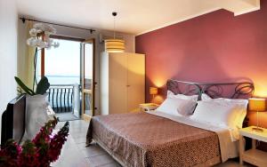 een slaapkamer met een bed met een rode muur bij Hotel Amarea - Aeolian Charme in Canneto