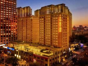 a large building with lights on in a city at night at Sky World Hotel Qingdao in Qingdao