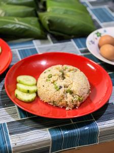 姆鲁Adventureswithst Homestay的桌上放着一盘红色的食物，里面有黄瓜。