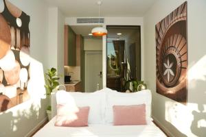a bedroom with a white bed with pink pillows at Moonlight Apartments Tirana in Tirana