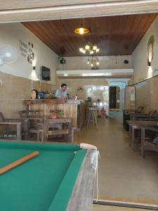 a man standing in a restaurant with a pool table at The Panda Backpacker Hostel in Kampot