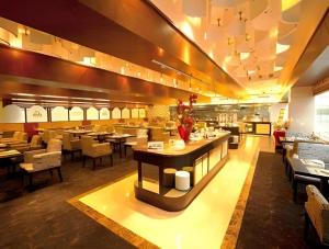 Changchun Zhuozhan Days Hotel في تشانغتشون: مطعم مع طاولات وكراسي وبوفيه