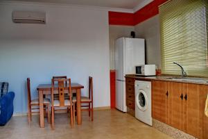 Una cocina con mesa y sillas y un refrigerador. en Chalet Arroyo Peñuelas 41, en Conil de la Frontera 16 fotos más