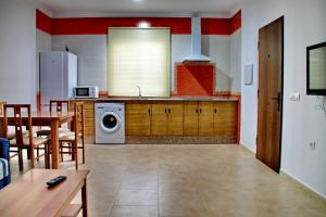 cocina con mesa y lavadora en Chalet Arroyo Peñuelas 41, en Conil de la Frontera