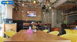a wooden table in a restaurant with yellow chairs at An Hotel Jakarta in Jakarta