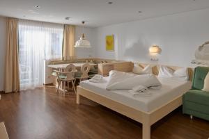 Un dormitorio con una cama y una mesa y sillas. en Alpenhaus Montafon by Pferd auf Wolke, en Gargellen