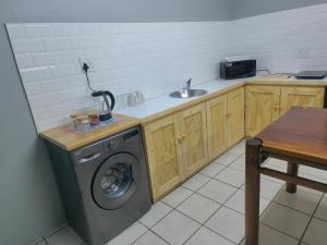 a kitchen with a washing machine and a sink at WegkruiperQ 2 in Beaufort West