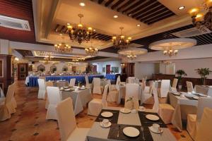 a banquet hall with white tables and white chairs at New century Manju Select Hotel Hongqiao Hub National Exhibition Center in Shanghai