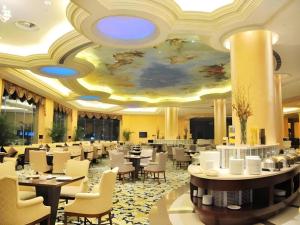 Country Garden Phoenix Hotel Huangshan في هوانغشان: غرفة طعام بها طاولات وكراسي وسقف