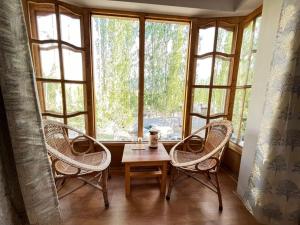 a room with two chairs and a table in front of a window at Hotel Namgyal Villa in Nubra