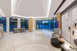 Un vestíbulo con sillas y mesas en un edificio. en City Comfort Inn Wuhan Badajia Heping Park Metro Station, en Wuhan