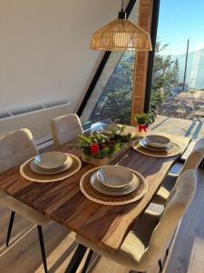 a wooden table with chairs and plates on it at Wild Hill Apuseni in Gârda de Sus