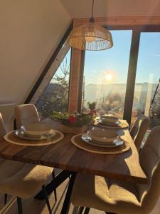 un tavolo da pranzo con sedie e una grande finestra di Wild Hill Apuseni a Gârda de Sus