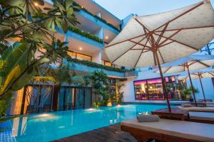 a swimming pool with an umbrella next to a building at Apsara Residence Hotel in Siem Reap
