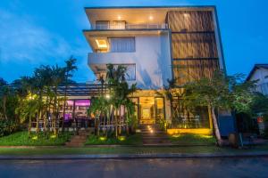 a building with palm trees in front of it at Apsara Residence Hotel in Siem Reap