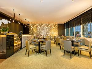 un restaurante con mesas, sillas y luces en Flora Creek Deluxe Hotel Apartments, en Dubái