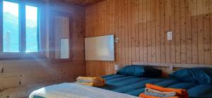 a bedroom with a bed in a wooden wall at Appartement Valaisan typique in Guttet-Feschel