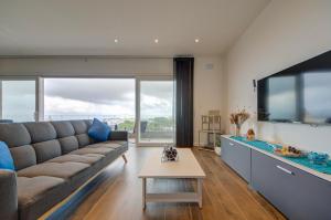 a living room with a couch and a large aquarium at Ridge View Rooms - in a Shared Apartment - Sea Views in Mellieħa