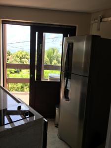 uma cozinha com um frigorífico de aço inoxidável em frente a uma porta em Farol da Rata em Fernando de Noronha mais 17 fotografias