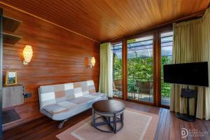 ein Wohnzimmer mit einem weißen Sofa und einem Fernseher in der Unterkunft Alamu Eco Lodge in Bedugul
