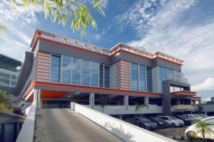 a building with cars parked in a parking lot at Aria Barito Hotel in Banjarmasin