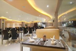 a restaurant with tables and chairs in a building at Aria Barito Hotel in Banjarmasin