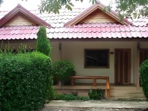 una casa con techo rosa con un banco al frente en Seaza Hotel, en Ban Khu Khut (1)