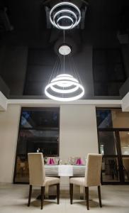 a dining room with two chairs and a light fixture at TeoDorka Med & SPA in Ciechocinek