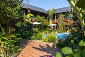 万象Champa Phan Boutique Hotel的一栋建筑前有游泳池的度假村