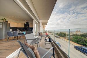 a house with a balcony with a view of the city at Ridge View Rooms - in a Shared Apartment - Sea Views in Mellieħa