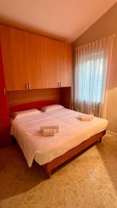 a bedroom with a large bed with two towels on it at Villa Angiolina in Bardolino +14 photos