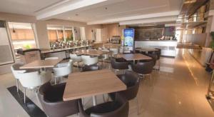 a restaurant with tables and chairs and a bar at ZUZU Simpang Lima in Semarang