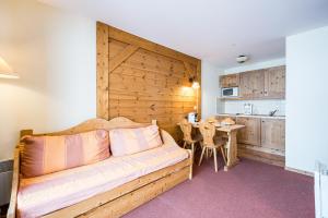 ein Wohnzimmer mit Sofa und Tisch in der Unterkunft Le Chalet - C204 - Vue Montagne in Le Corbier