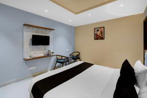 una camera d'albergo con un letto e una televisione di Hotel O Sri Aditya Utsav a Hakīmpet
