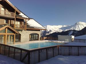 ein Haus mit Pool im Schnee in der Unterkunft Le Chalet - C204 - Vue Montagne in Le Corbier