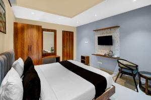 una camera da letto con un grande letto bianco e una sedia di Hotel O Sri Aditya Utsav a Hakīmpet