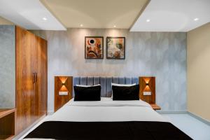 una camera da letto con un letto grande con due lampade di Hotel O Sri Aditya Utsav a Hakīmpet
