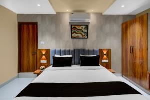 una camera da letto con un grande letto bianco con cuscini neri di Hotel O Sri Aditya Utsav a Hakīmpet