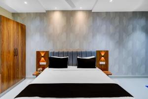 una camera da letto con un grande letto bianco con cuscini neri di Hotel O Sri Aditya Utsav a Hakīmpet Altre 22 foto
