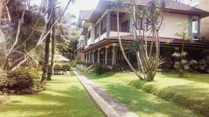 una casa con palmeras delante en The Oxalis Regency Hotel, en Magelang