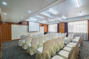 a conference room with white chairs and a screen at James Joyce Coffetel Tianjin Railway Station Jinshiqiao Metro Station Branch in Tianjin
