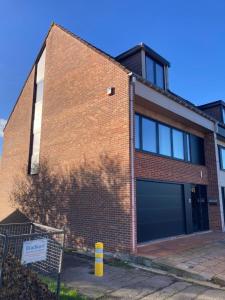 un edificio de ladrillo con dos puertas de garaje. en Holiday home in Bredene space & fun by the sea, en Bredene