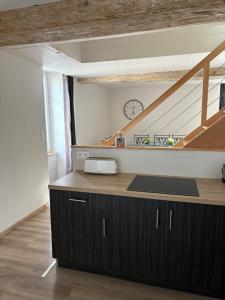 a kitchen with a counter with a clock on the wall at Les Glaneuses gîte Entre Amis centre-bourg à 3 min du Puy duFou in Les Épesses +83 photos