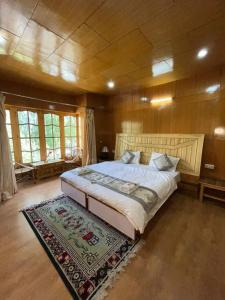 a bedroom with a large bed and a rug at Hotel Namgyal Villa in Nubra
