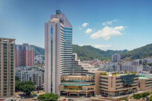 Noble Jasper Hotel Huizhou في هويزو: مبنى أبيض طويل في مدينة كبيرة