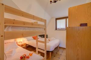 a bedroom with two bunk beds and a window at Appartamento Nido Alpino - Happy Rentals in Souchères Basses
