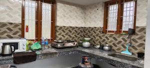 a kitchen counter with a sink and a microwave at MistyKera in Vattavada +1 photo